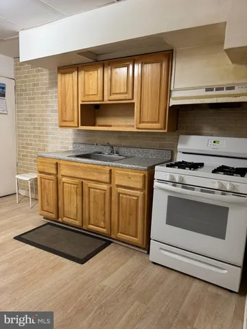 a kitchen with granite countertop a stove and a sink