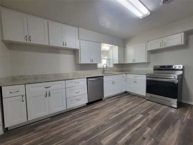 a kitchen with white cabinets stainless steel appliances and sink