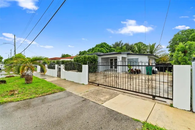 a view of a house with a small yard and wooden fence