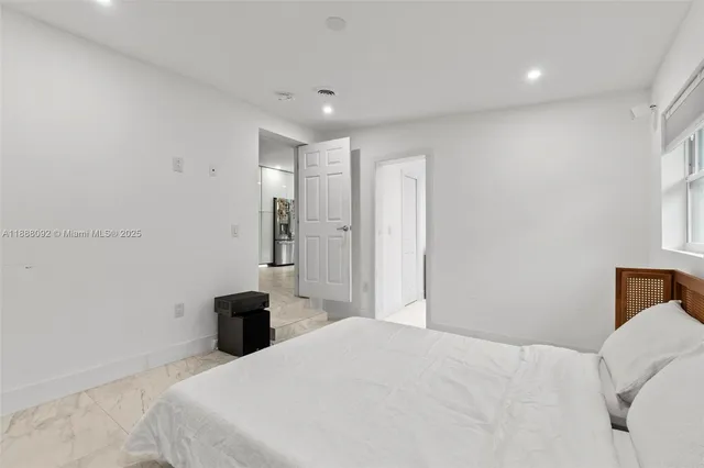 a bedroom with a bed and a large window