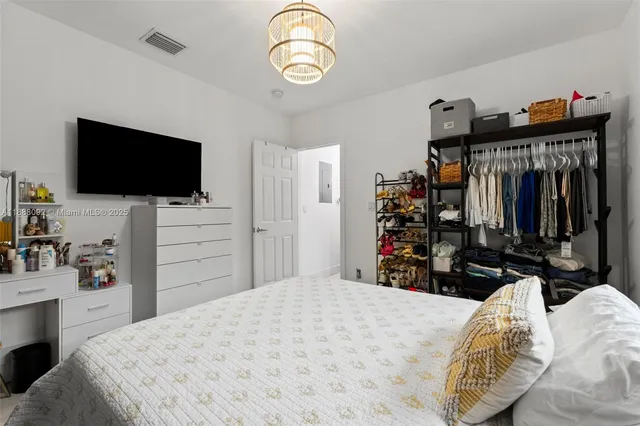 a bedroom with a bed and a flat tv screen on the dresser