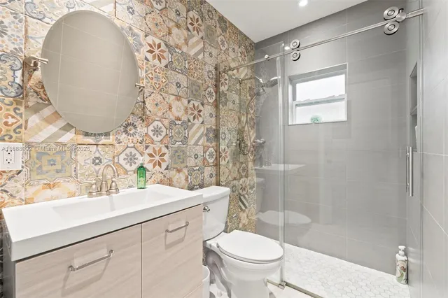 a bathroom with a sink mirror toilet and shower