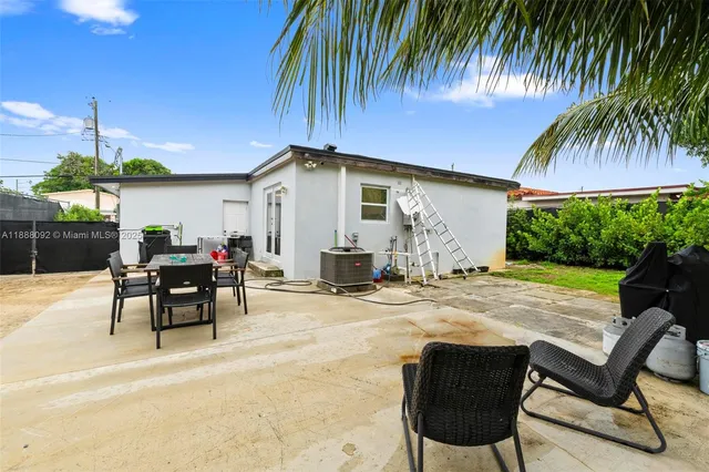 a view of a house with backyard and sitting area