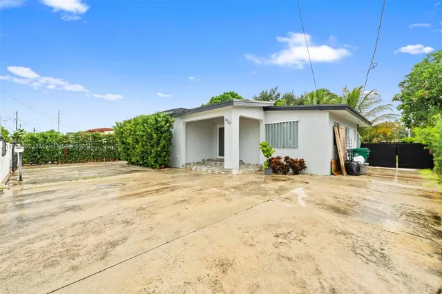 a view of a house with backyard and a tree