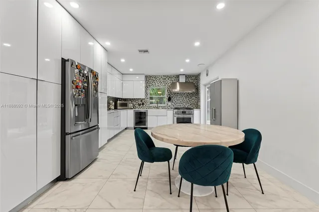 a kitchen with stainless steel appliances kitchen island granite countertop a refrigerator and a stove top oven