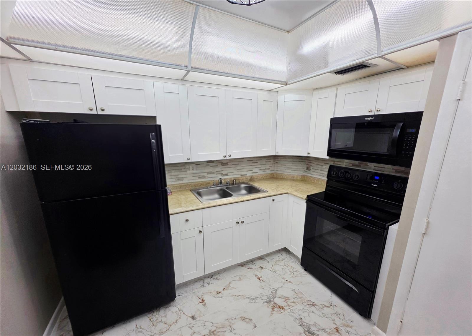 4164 Inverrary Drive, Unit 204 Lauderhill, FL 33319 - Photo 13 of 28 a kitchen with a refrigerator stove and microwave