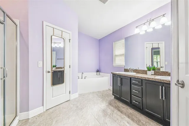 a spacious bathroom with a tub sink shower and mirror