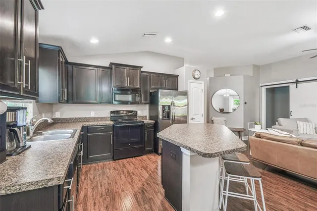 a kitchen with stainless steel appliances granite countertop a sink stove and refrigerator
