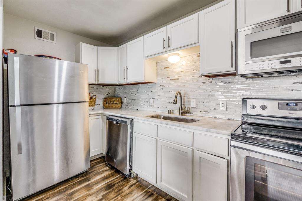 4347 Dickason Avenue, Unit 110 Dallas, TX 75219 - Photo 14 of 24 a kitchen with stainless steel appliances granite countertop a refrigerator sink and stove