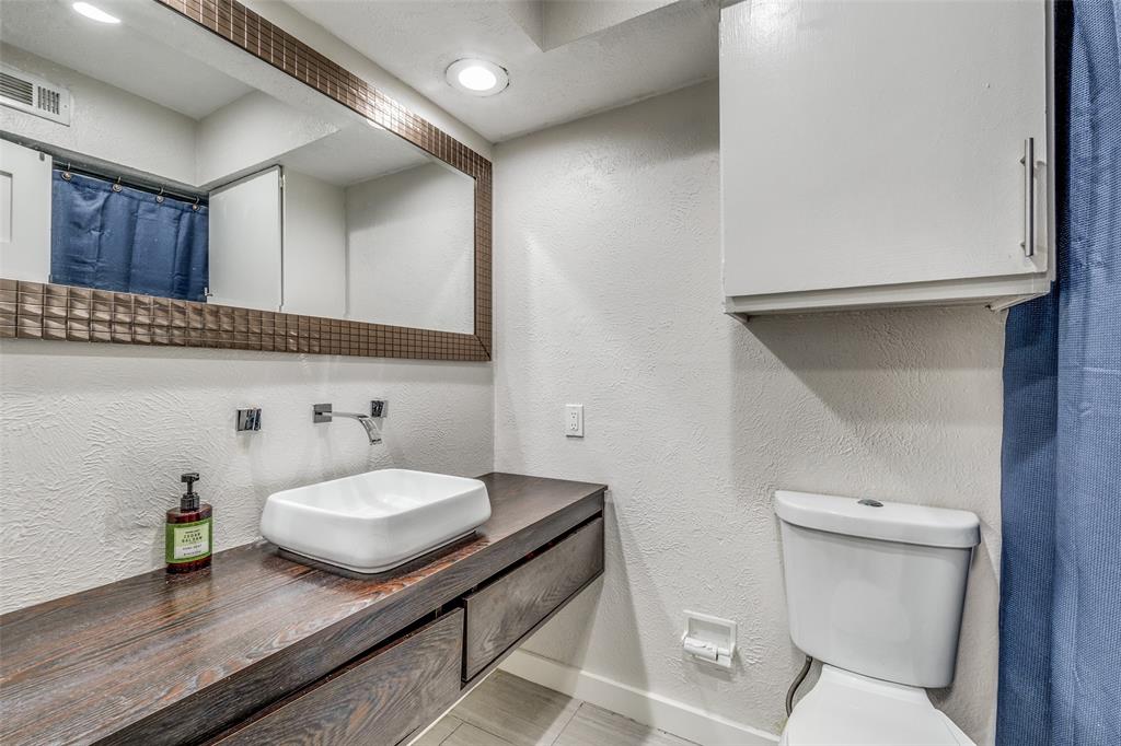 4347 Dickason Avenue, Unit 110 Dallas, TX 75219 - Photo 17 of 24 a bathroom with a sink and a toilet