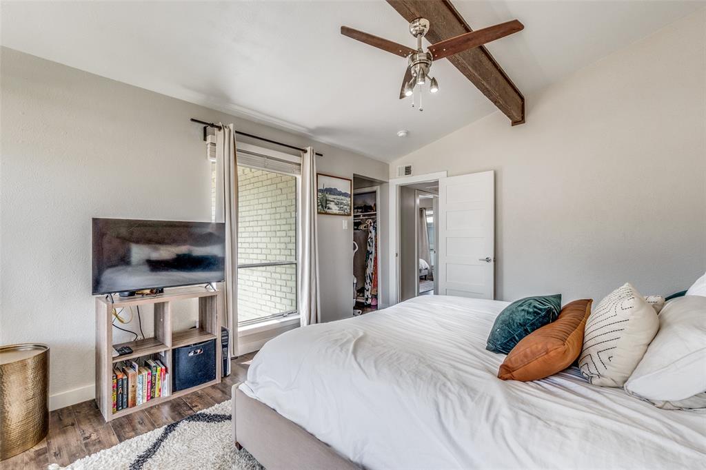 4347 Dickason Avenue, Unit 110 Dallas, TX 75219 - Photo 21 of 24 a bedroom with a bed a flat screen tv and a book shelf