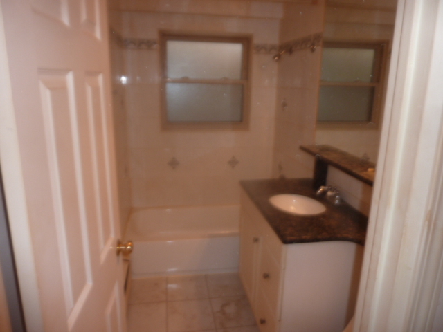 6733 West Irving Park Road, Unit 2C Chicago, IL 60634 - Photo 7 of 10 a bathroom with a sink and mirror