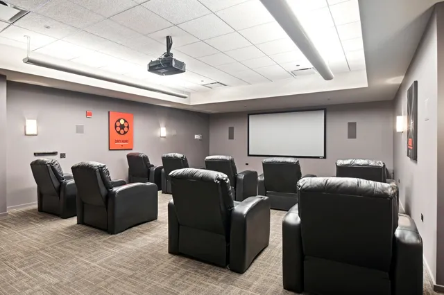 a media room with lots of chairs and a projector screen