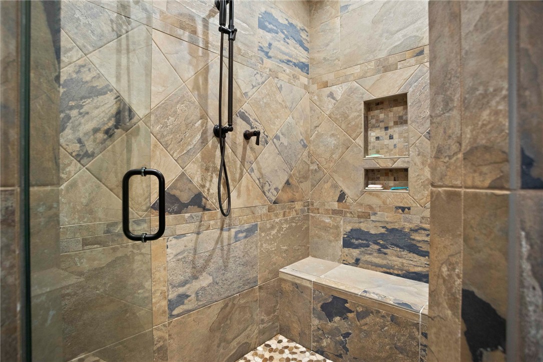 236 Palmer Way Sunset, SC 29685 - Photo 18 of 46 Natural stone tilework and a built-in bench create a rejuvenating shower experience.