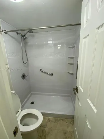 a bathroom with a toilet and a shower