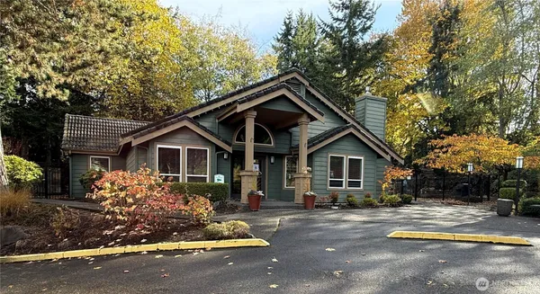 a front view of house with yard and trees in the background