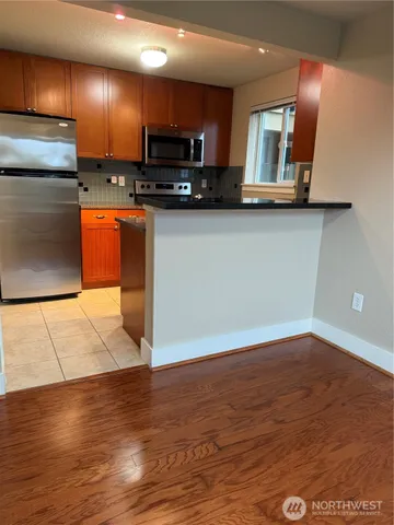 a kitchen with stainless steel appliances a refrigerator sink stove microwave and cabinets