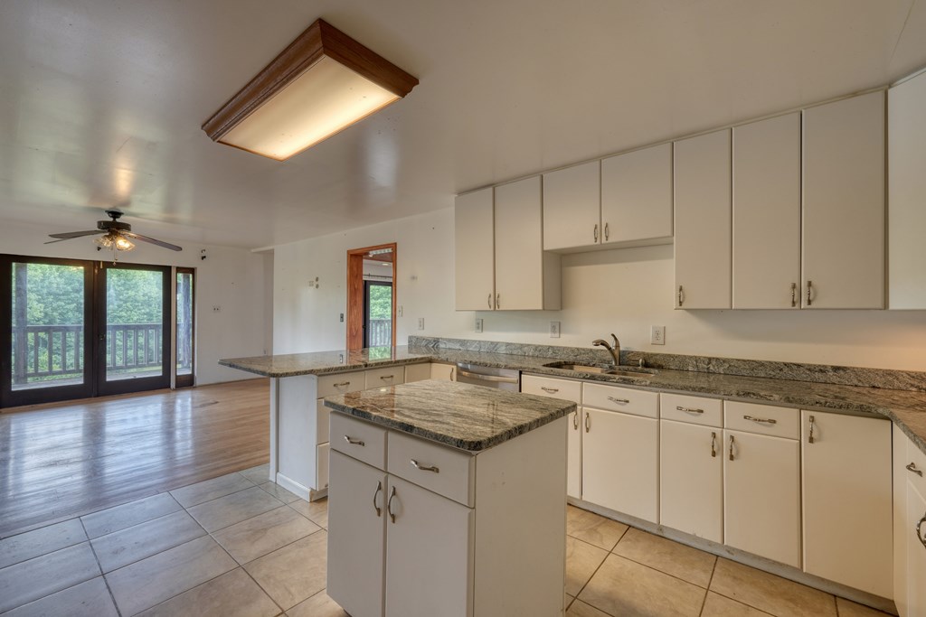 89 Simmons Ridge Mineral Bluff, GA 30559 - Photo 24 of 82 a kitchen with a sink dishwasher and white cabinets with wooden floor