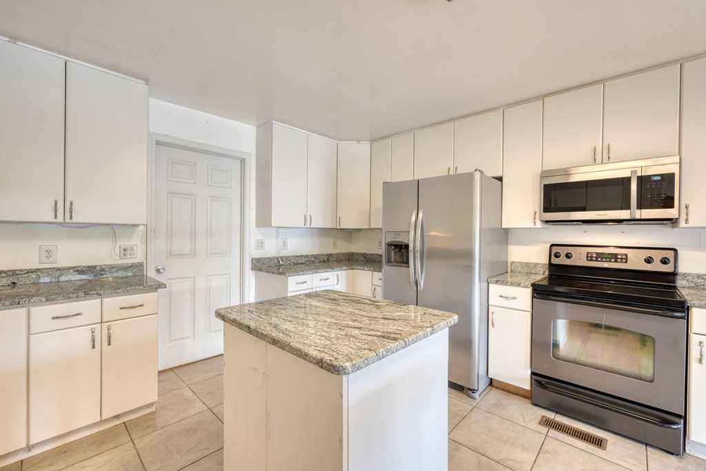 89 Simmons Ridge Mineral Bluff, GA 30559 - Photo 8 of 82 a kitchen with granite countertop a stove microwave and refrigerator