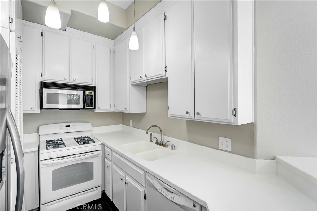 6140 Monterey Road, Unit 406 Los Angeles, CA 90042 - Photo 6 of 26 a kitchen with white cabinets and white appliances