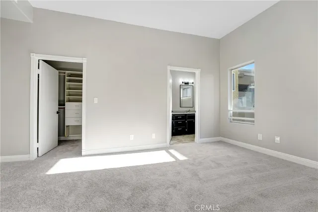 an empty room with closet and windows