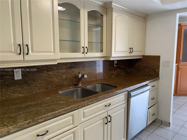 a kitchen with granite countertop a sink and cabinets