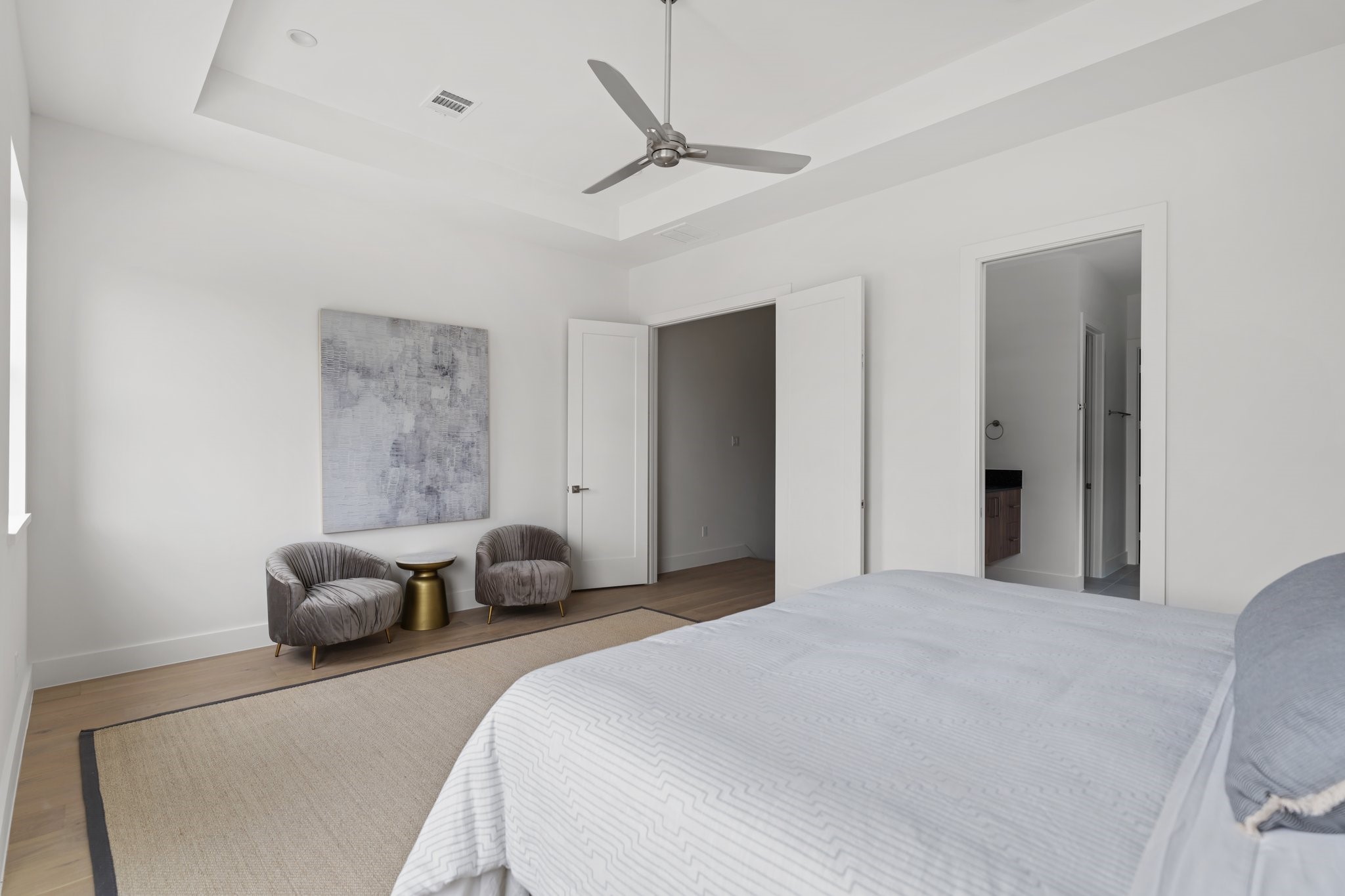 111 East 32nd Street, Unit C Houston, TX 77018 - Photo 17 of 31 Indulgent primary suite with a dedicated seating area, abundant natural light from oversized windows, and exclusive access through elegant French doors.