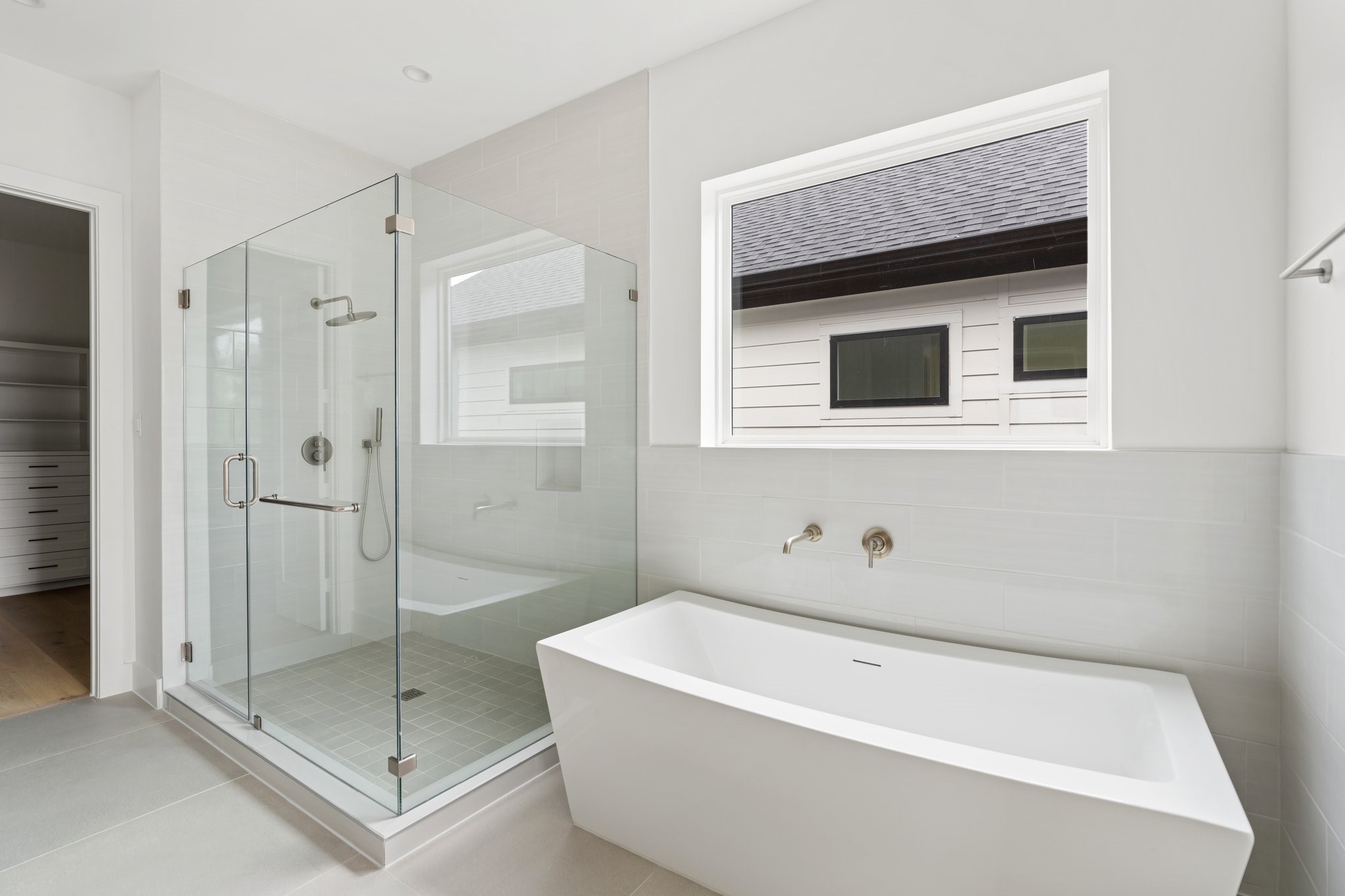 111 East 32nd Street, Unit C Houston, TX 77018 - Photo 19 of 31 Spa-like primary bath with a frameless glass walk-in shower and a freestanding soaking tub.