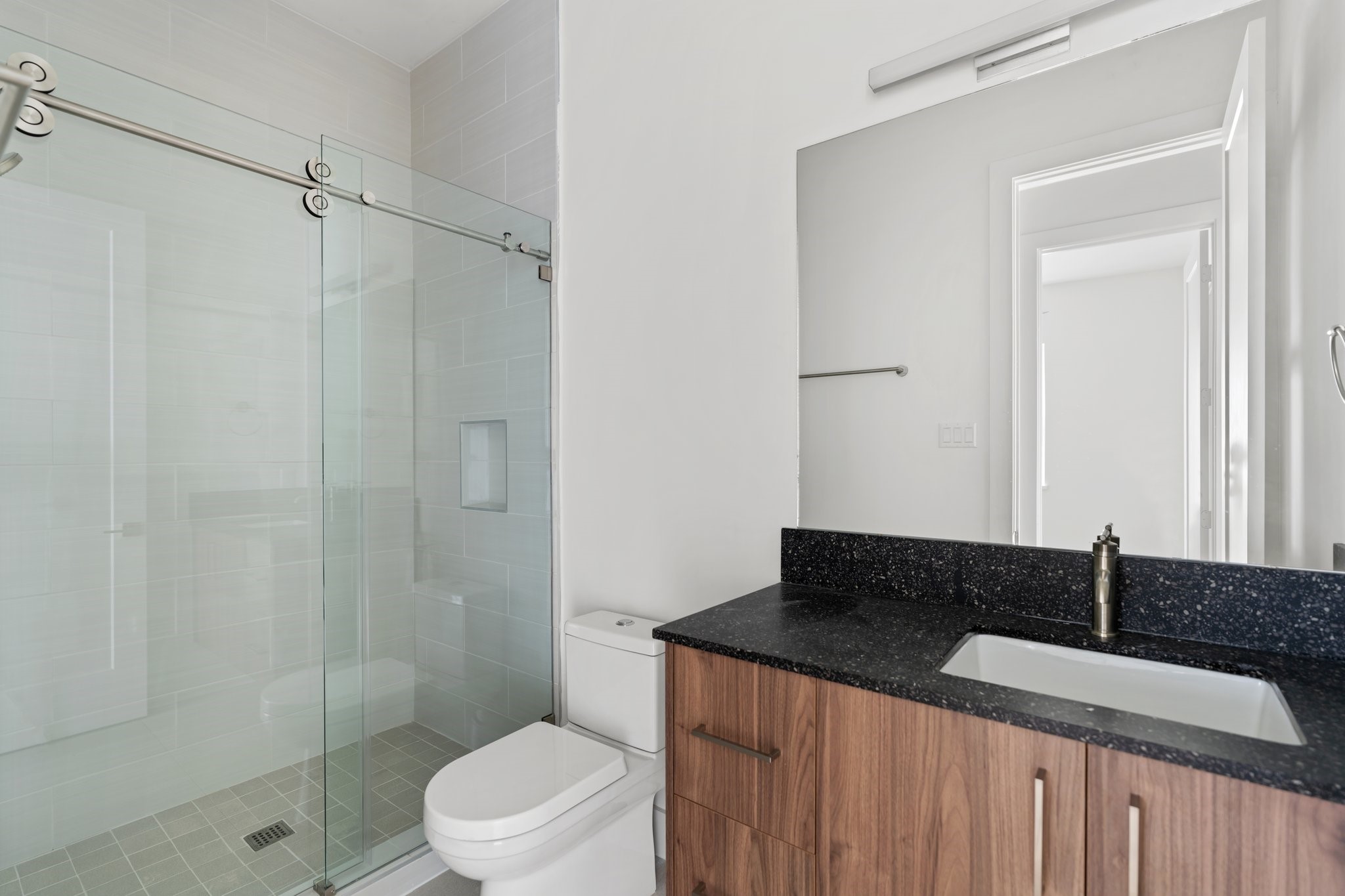 111 East 32nd Street, Unit C Houston, TX 77018 - Photo 24 of 31 Stylish shared bath with a walk-in shower, Moen plumbing fixtures, and custom cabinetry by GoBravura.