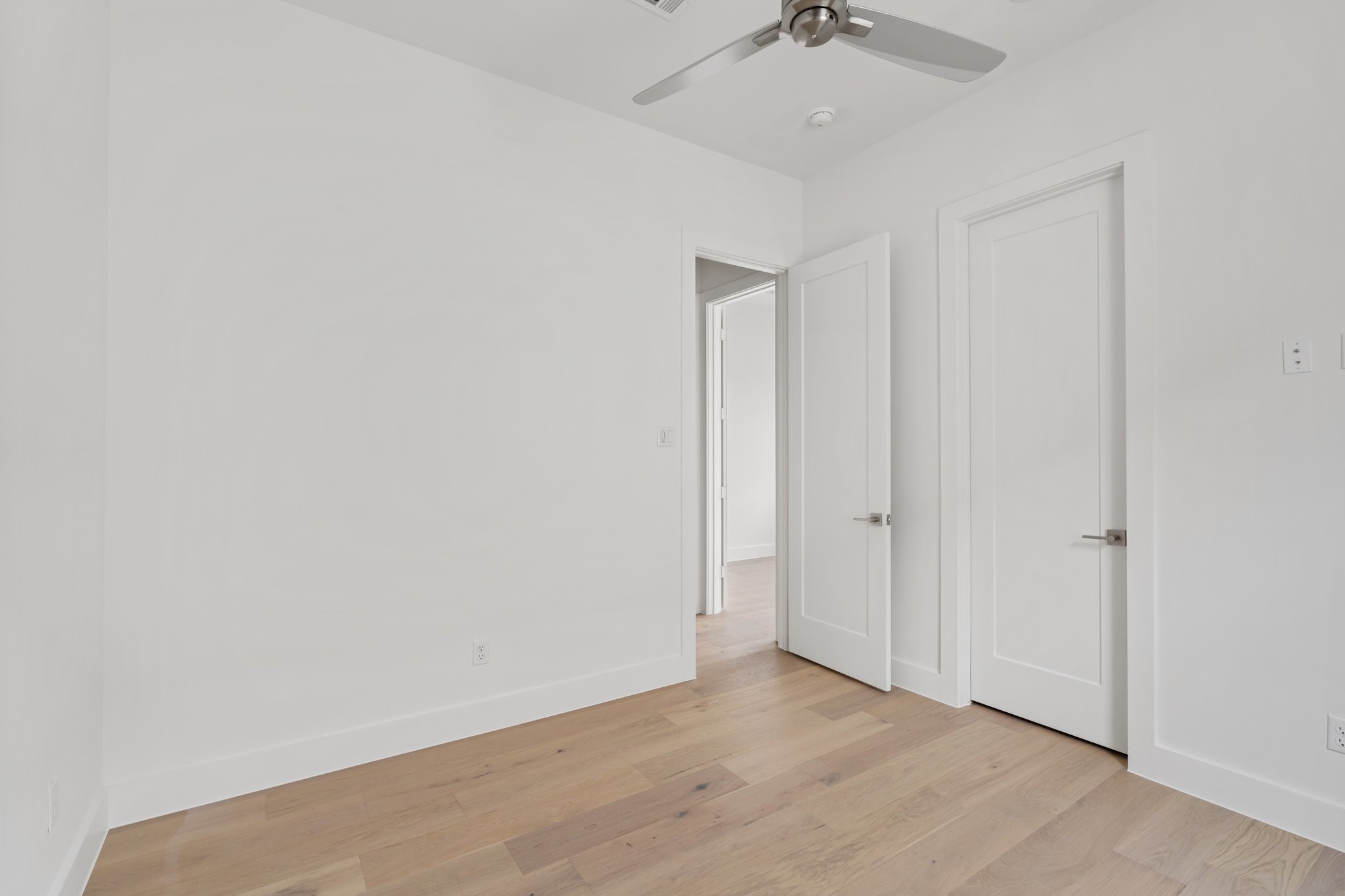 111 East 32nd Street, Unit C Houston, TX 77018 - Photo 26 of 31 Natural light fills the space, complemented by a MinkaAire ceiling fan and warm wood flooring.