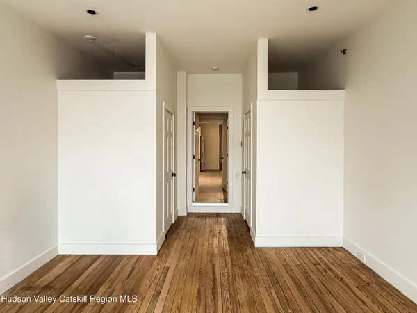 a view of a hallway with wooden floor