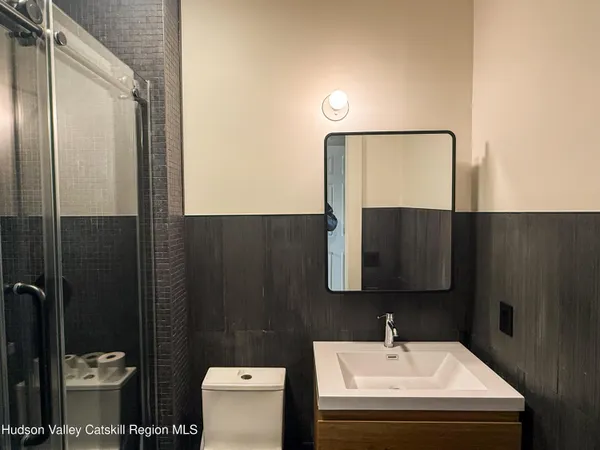 a bathroom with a sink toilet and mirror