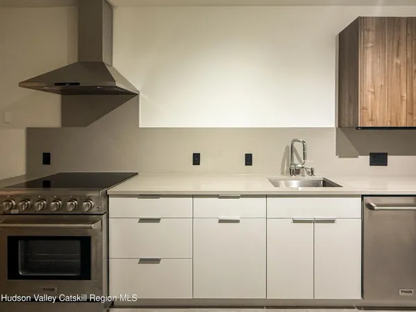 a kitchen with granite countertop a sink a stove and cabinets