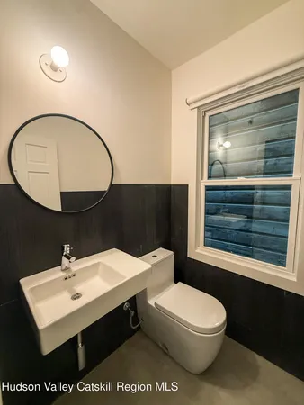 a bathroom with a sink a toilet and mirror