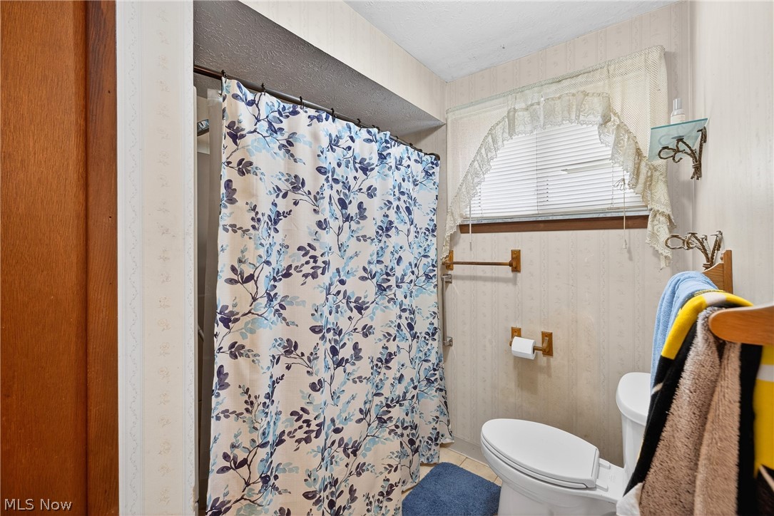 4404 Florida Street Perry, OH 44081 - Photo 17 of 24 Bathroom featuring a shower with shower curtain, light tile patterned floors, and wallpapered walls
