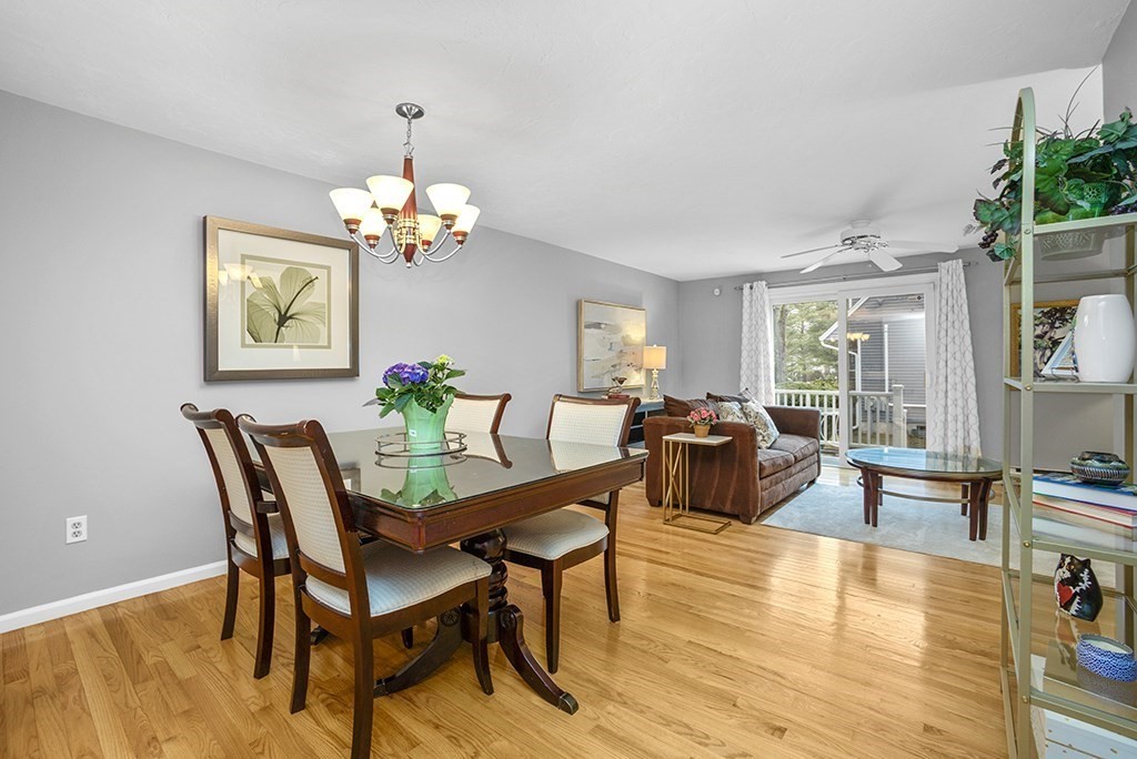 78 Key Street, Unit 78 Millis, MA 02054 - Photo 15 of 33 a dining room with wooden floor a chandelier a glass table and chairs