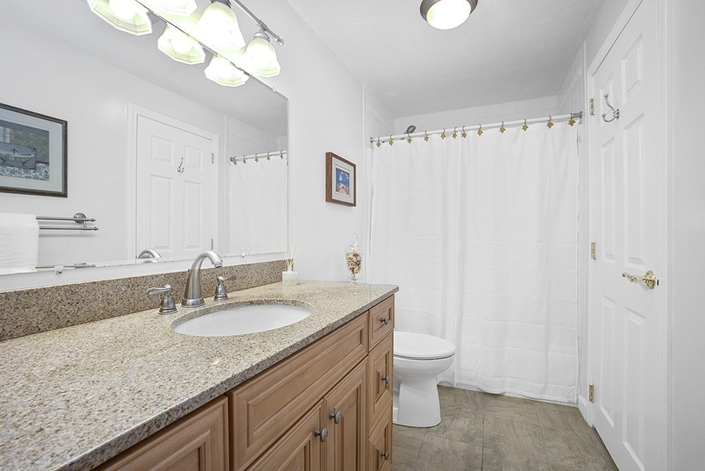 78 Key Street, Unit 78 Millis, MA 02054 - Photo 23 of 33 a bathroom with a granite countertop sink a toilet and a mirror