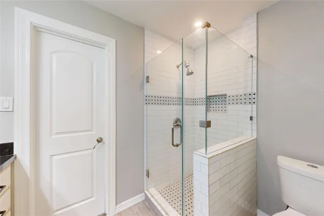 a bathroom with a shower a toilet and sink