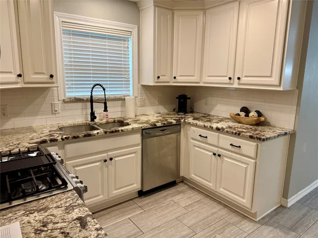a kitchen with appliances a sink and cabinets