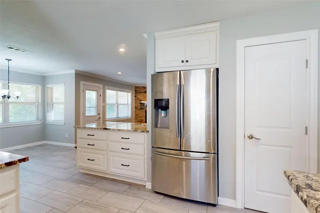 a kitchen with cabinets stainless steel appliances and a window
