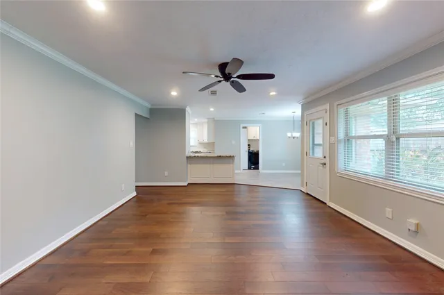 a view of an empty room with a window and wooden floor