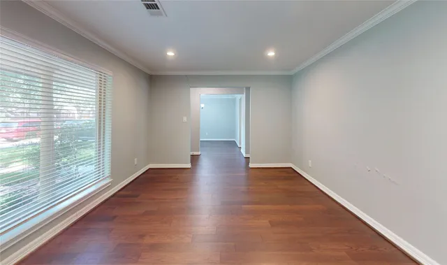 a view of a big room with wooden floor and windows
