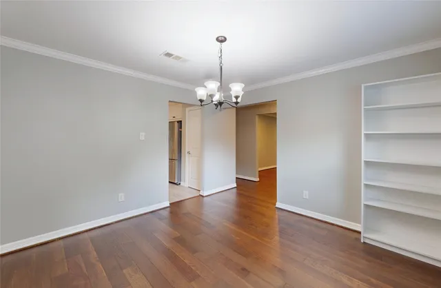 a view of a room with wooden floor and chandelier