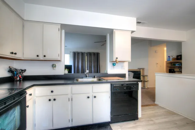a kitchen with granite countertop a sink a stove and cabinets