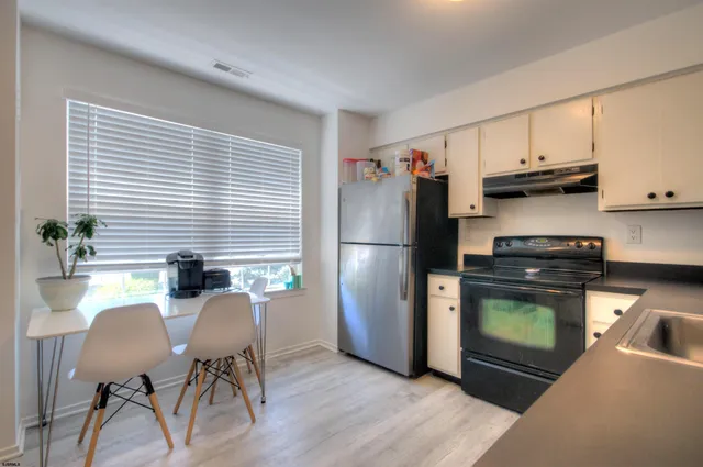 a kitchen with stainless steel appliances granite countertop a refrigerator and a stove top oven