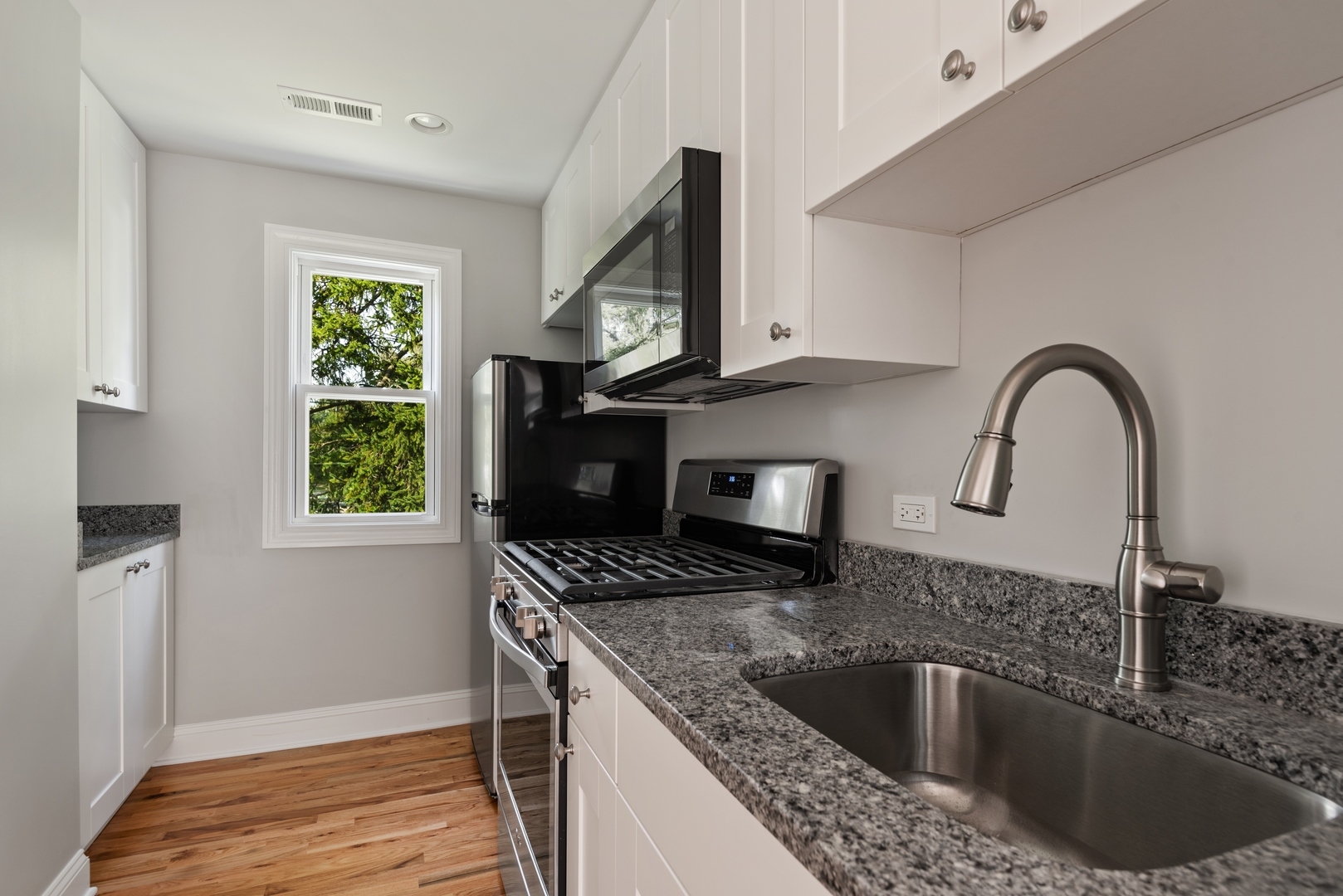 1131 Ridge Road, Unit 2 Wilmette, IL 60091 - Photo 5 of 11 a kitchen with kitchen island granite countertop a sink a counter top space and cabinets