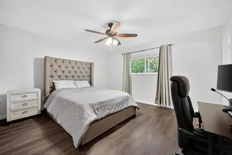 a bedroom with a bed a chandelier and a window