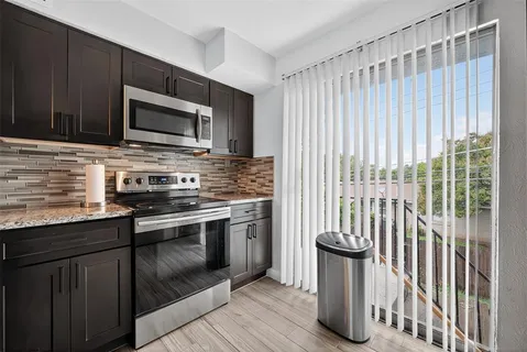 a kitchen with stainless steel appliances granite countertop a stove a sink and a microwave