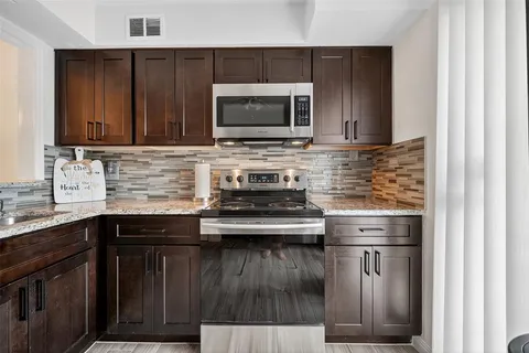 a kitchen with stainless steel appliances a sink and a microwave