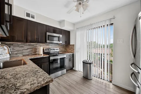 a kitchen with granite countertop a stove and a sink